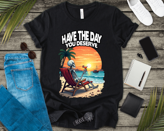 Have the Day You Deserve Tshirt – Relaxing Skeleton with Drink on Beach Sunset